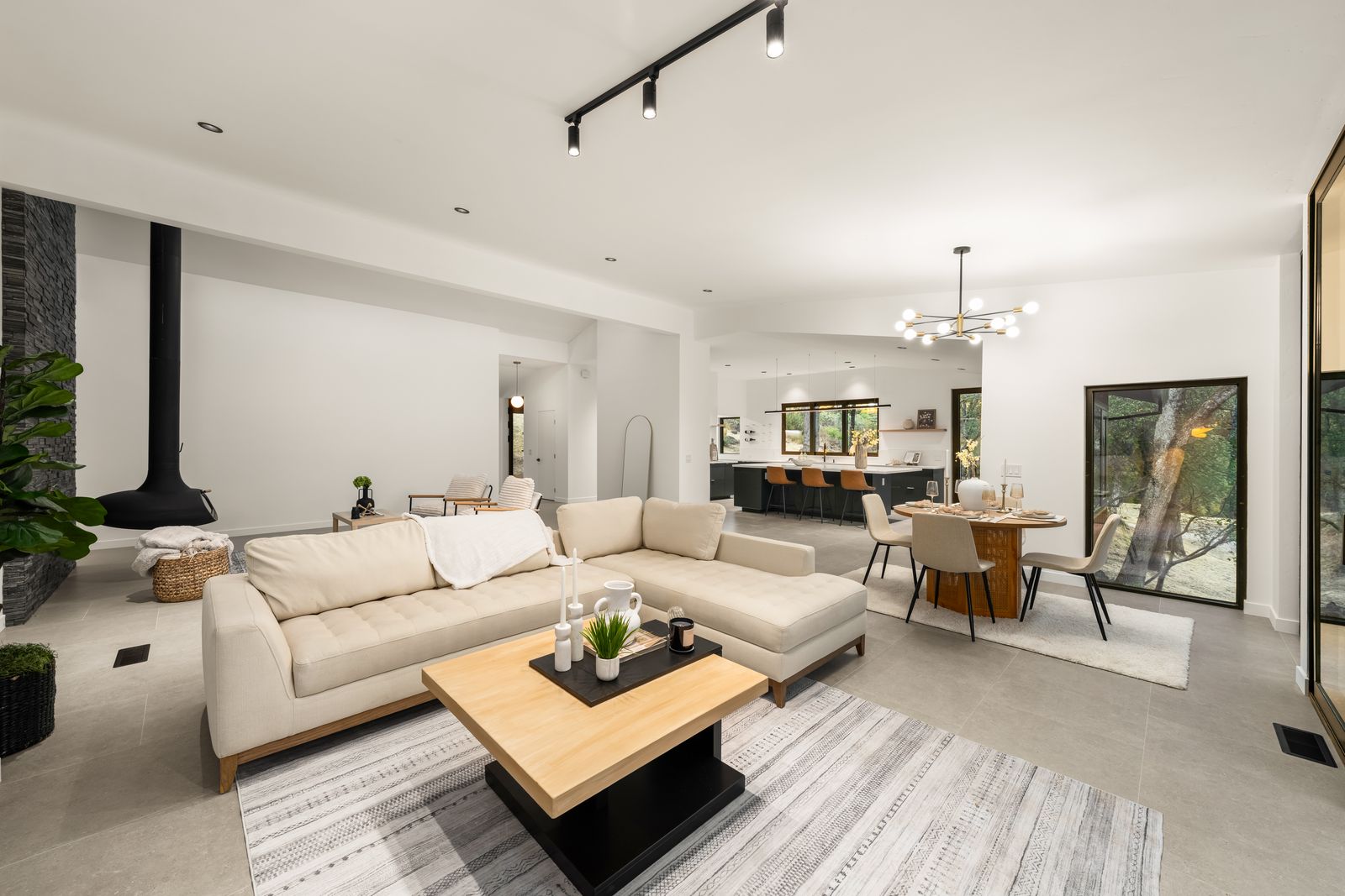 Open living, dining, and kitchen with wide-plank flooring and oak views