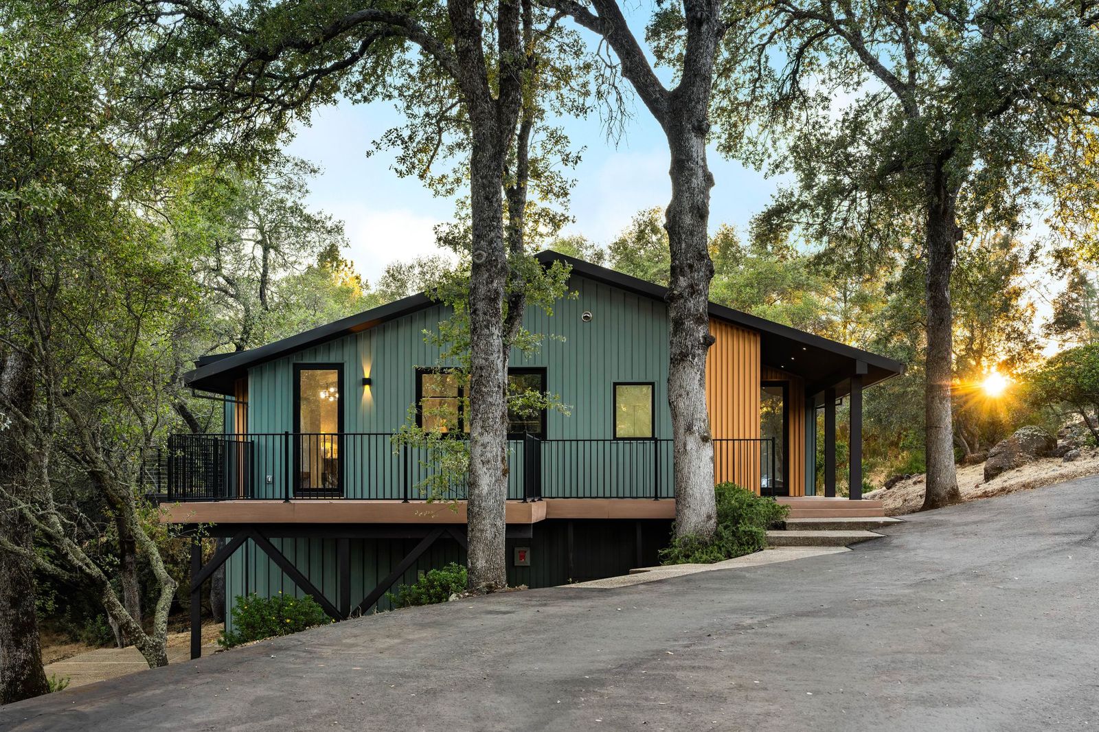 Home nestled among mature oaks at sunset